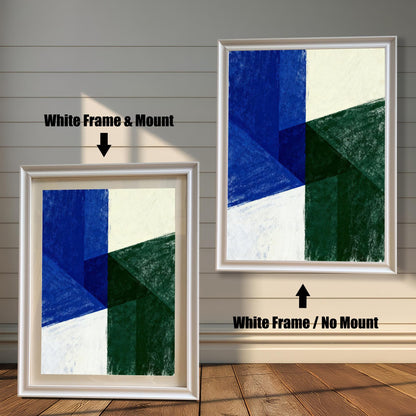 Comparison image of two framed prints against a light wooden wall. The left print shows a White Frame & Mount (with a beige border/mat). The right print shows a larger White Frame / No Mount. Both display the same geometric abstract artwork in blue, green, and white.