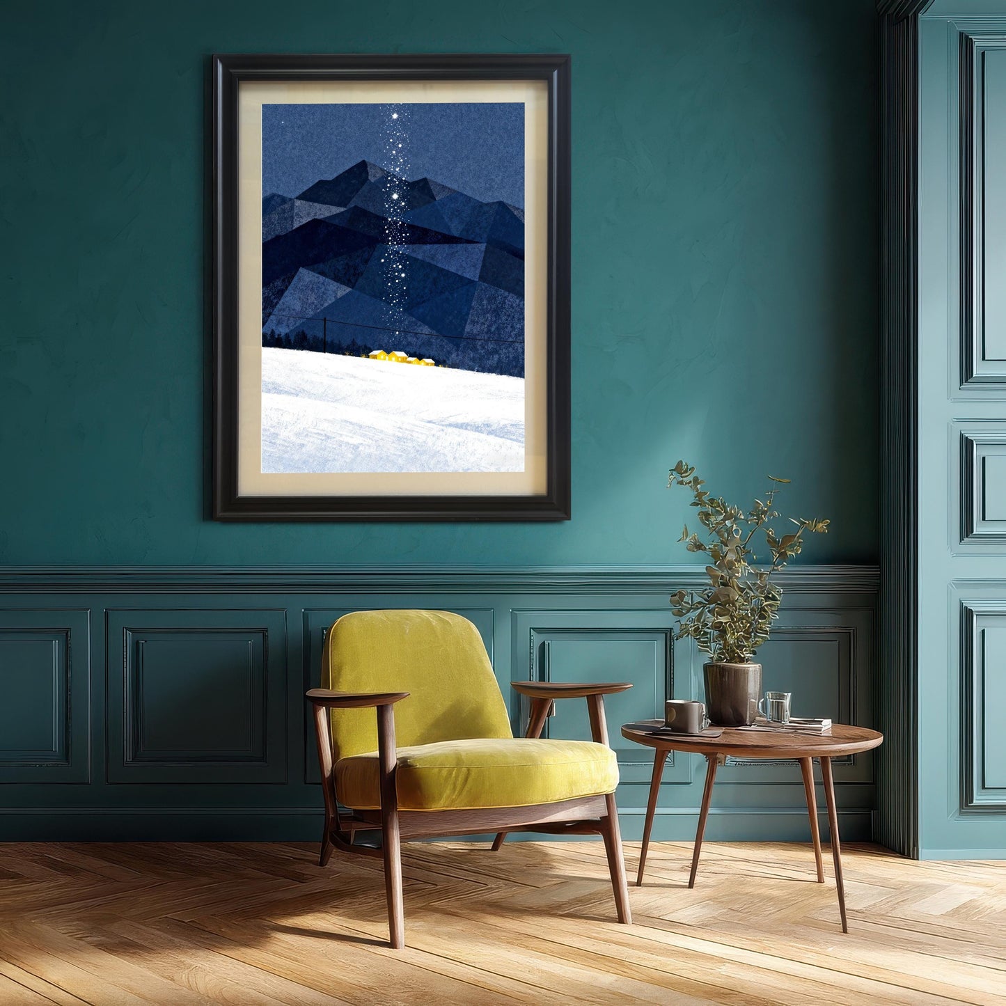 Framed art print with blue mountains and snow, hanging on a dark teal wall above a yellow mid-century modern armchair and a small wooden side table with a plant.