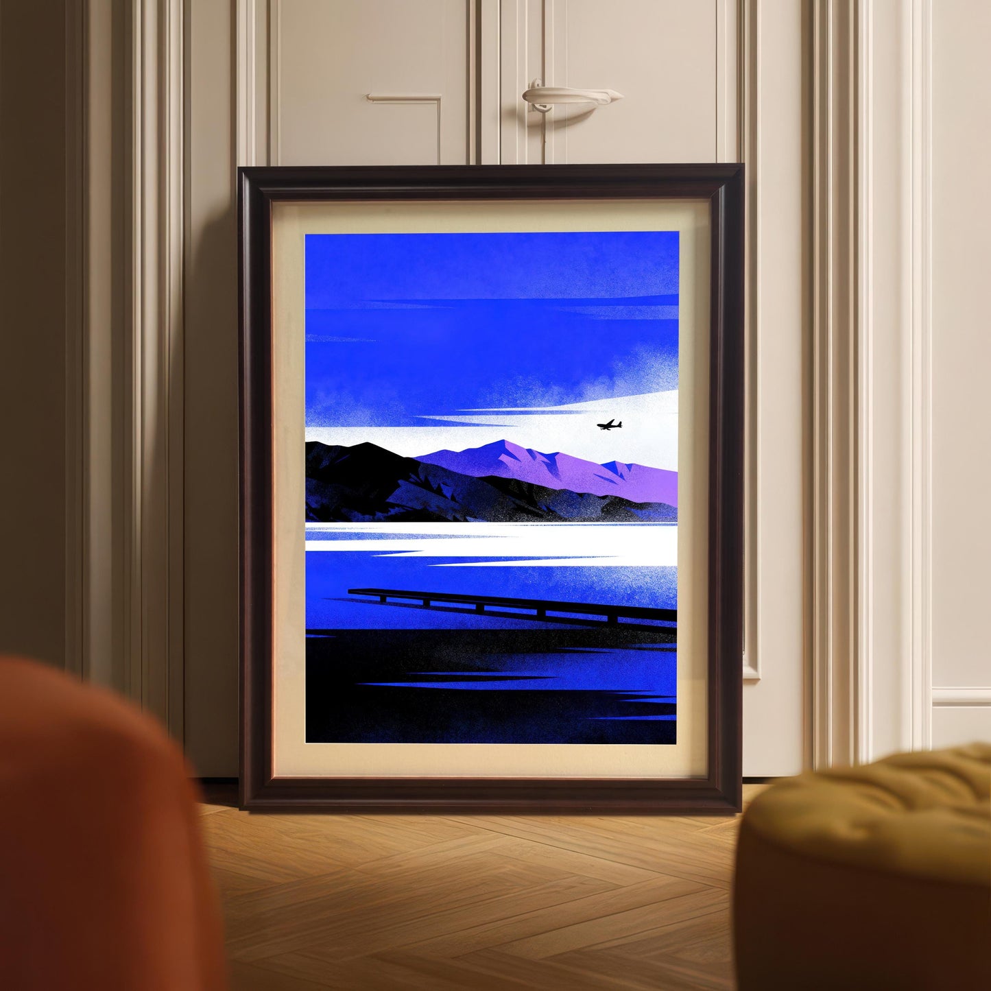 Blue Lake/Mountain	Large framed Blue Lake/Mountain art print in a Coffee Frame with a mount, leaning against white paneled doors, with an orange ottoman visible in the foreground.
