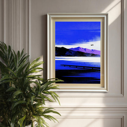 Framed Blue Lake/Mountain art print in a White Frame with a mount, hanging on a beige paneled wall next to a large potted green palm plant.