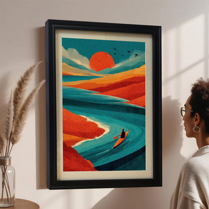 A person viewing a large black-framed landscape art print of a teal river and red sun, mounted on a neutral wall in a brightly lit room.