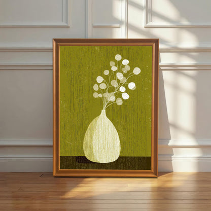 Large-scale olive green botanical art print in an orange wood frame leaning against a white wainscoted wall on a polished hardwood floor with window shadows.