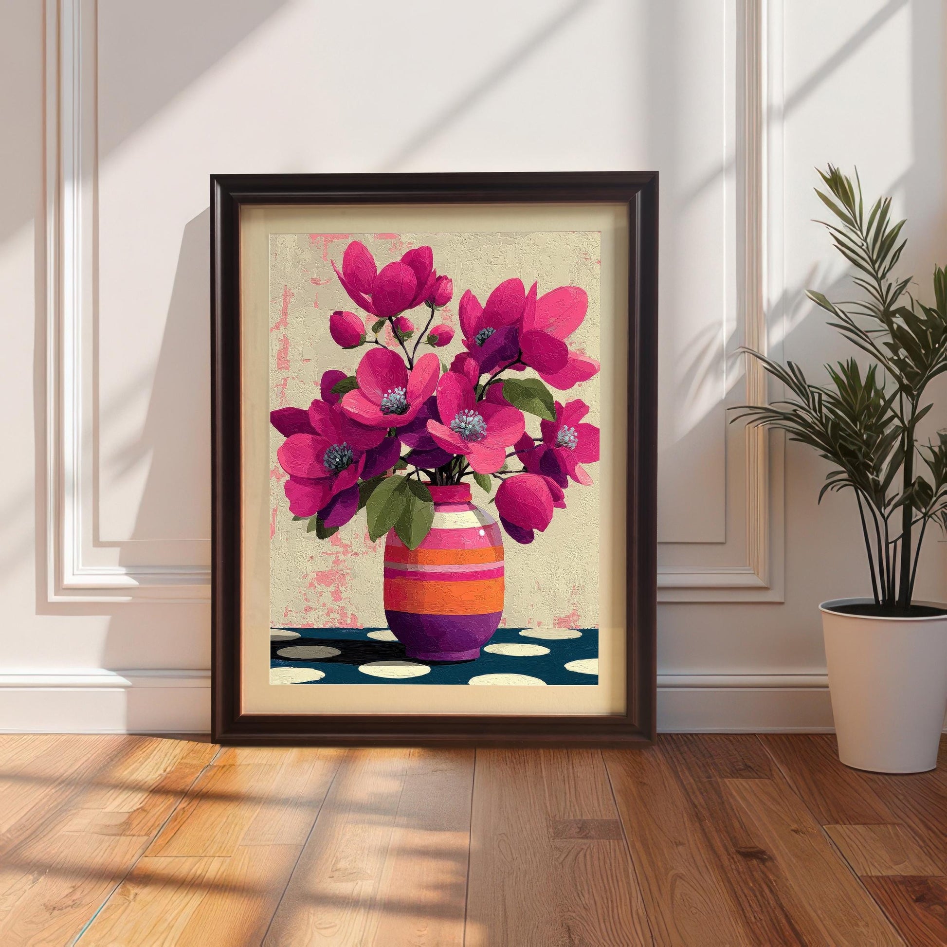 Dark coffee-colored wood frame with a white mount featuring a pink flower print, leaning against a classic paneled wall next to a potted plant.