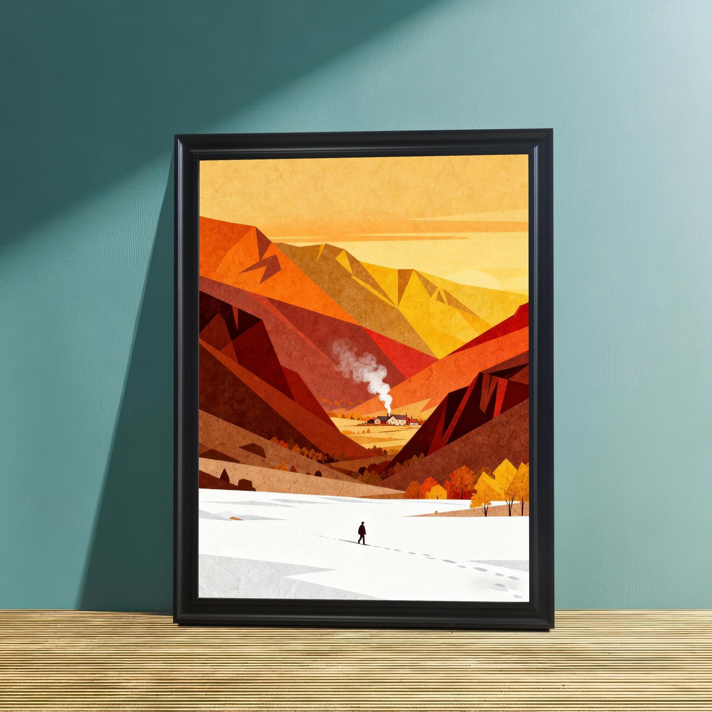 Minimalist mountain landscape art in a sleek black wood frame, leaning against a teal-colored wall on a textured wooden surface.