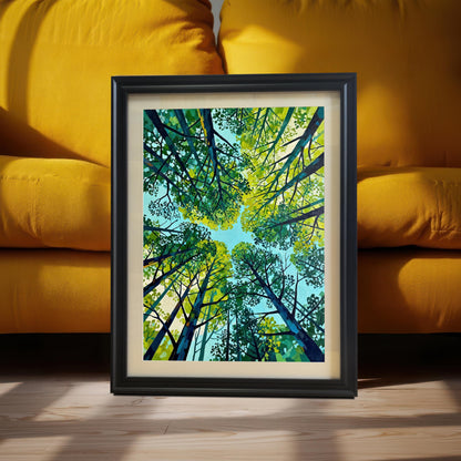 Close-up of a matted nature art print in a black wood frame, resting on a wooden floor against the cushions of a vibrant yellow sofa.