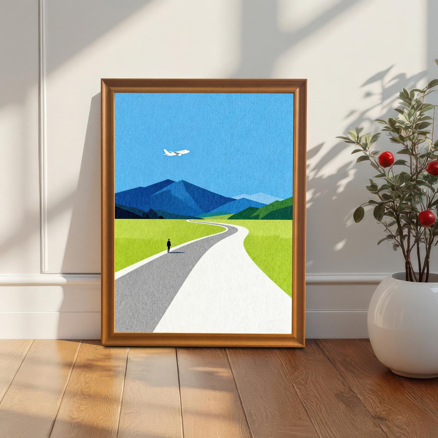 Modern wood framed art print of a serene landscape leaning against a white wall on a hardwood floor next to a white potted plant, showcasing a cozy home decor setting.