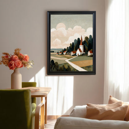 A large black-framed art print of a rural village landscape hanging on a white wall in a modern dining room with a green chair and floral arrangement.