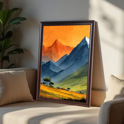 A coffee-colored wood frame featuring the mountain landscape print leaning against a sofa cushion. The warm lighting highlights the orange sky of the artwork and the texture of the frame.
