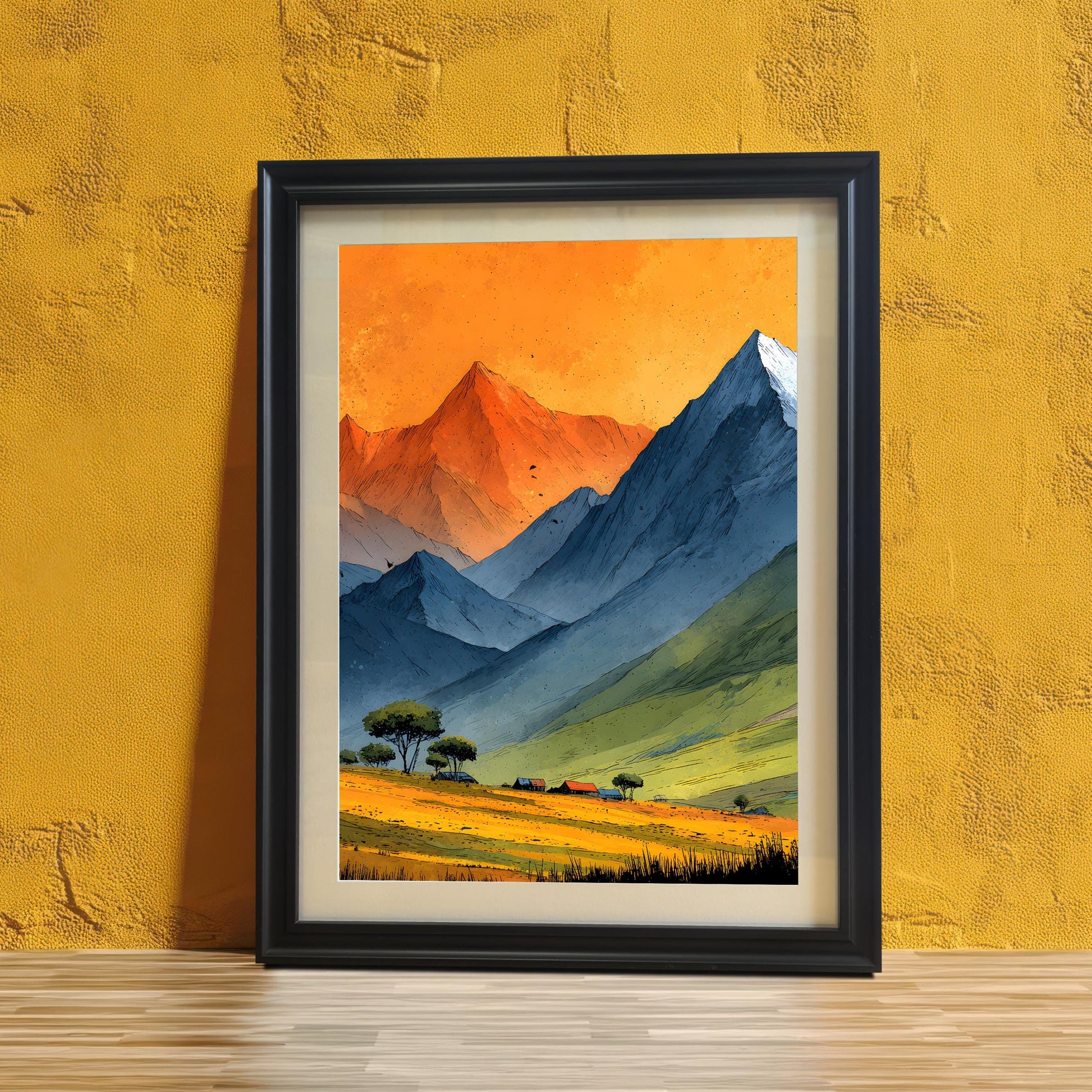 A framed mountain landscape art print leaning against a textured yellow wall on a light wood floor. The print features vibrant orange skies and blue mountains in a black wood frame with a white mount.
