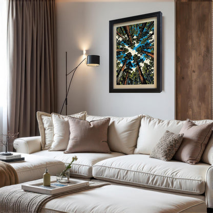 A black wood framed vertical forest art print hanging above a white sectional sofa in a modern, cozy living room with neutral decor.