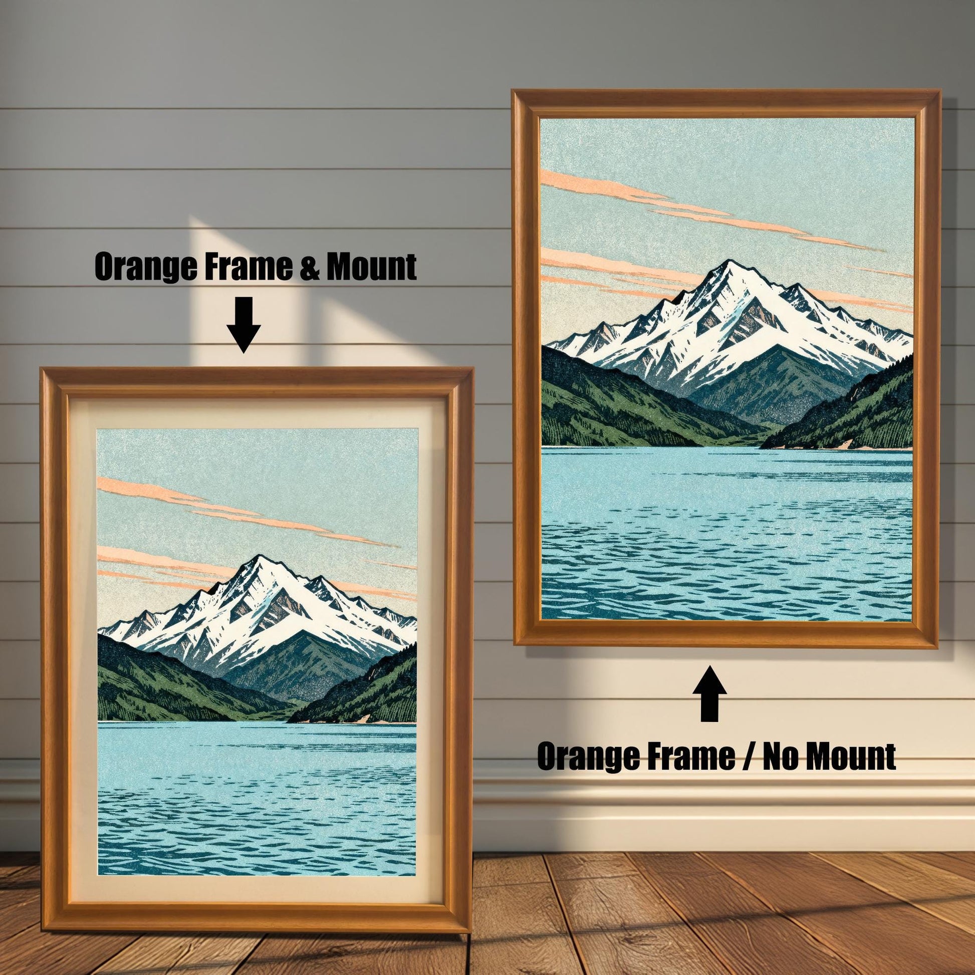 Two side-by-side examples of the mountain art print in orange wood frames; one features a cream-colored mat board (mount) and the other is a full-bleed print with no mount.