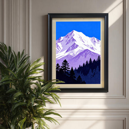 The purple and blue mountain art print in a 'Black' wood frame with a cream mount, displayed on a textured wall next to a large potted plant.