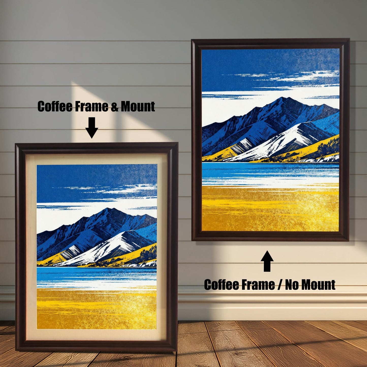 Two framed art prints on a wooden shiplap wall. Both prints feature the same blue and yellow mountain landscape. The left print shows the art in a Coffee Frame & Mount (matting). The right print shows the art in a Coffee Frame / No Mount.