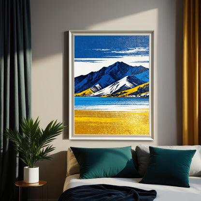 A framed art print in a white frame, featuring the blue and yellow mountain landscape, hanging above a bed with teal pillows. The scene is illuminated by sunlight filtering past dark teal and gold curtains.