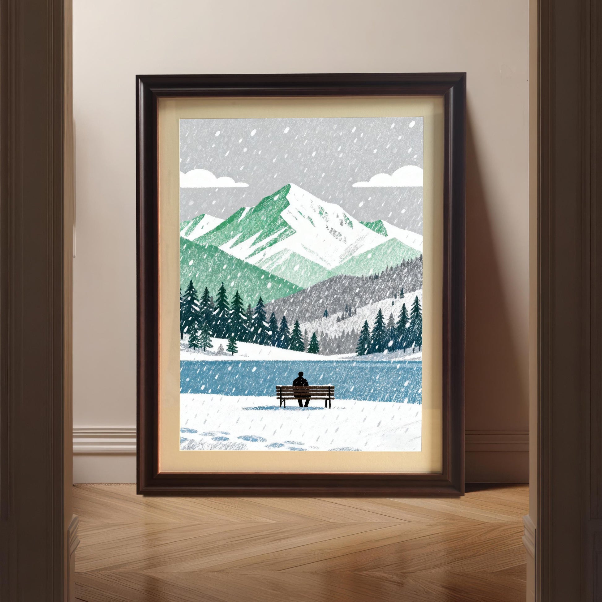 A framed art print in a dark wood 'Coffee' frame, standing on a wooden floor between an open doorway. The artwork is a winter scene with a person sitting on a bench by a lake.
