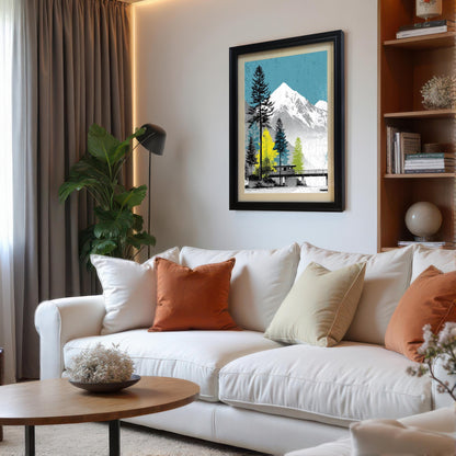 Black framed mountain landscape art print with an ivory mount, styled above a modern white sofa with orange cushions in a bright living room.