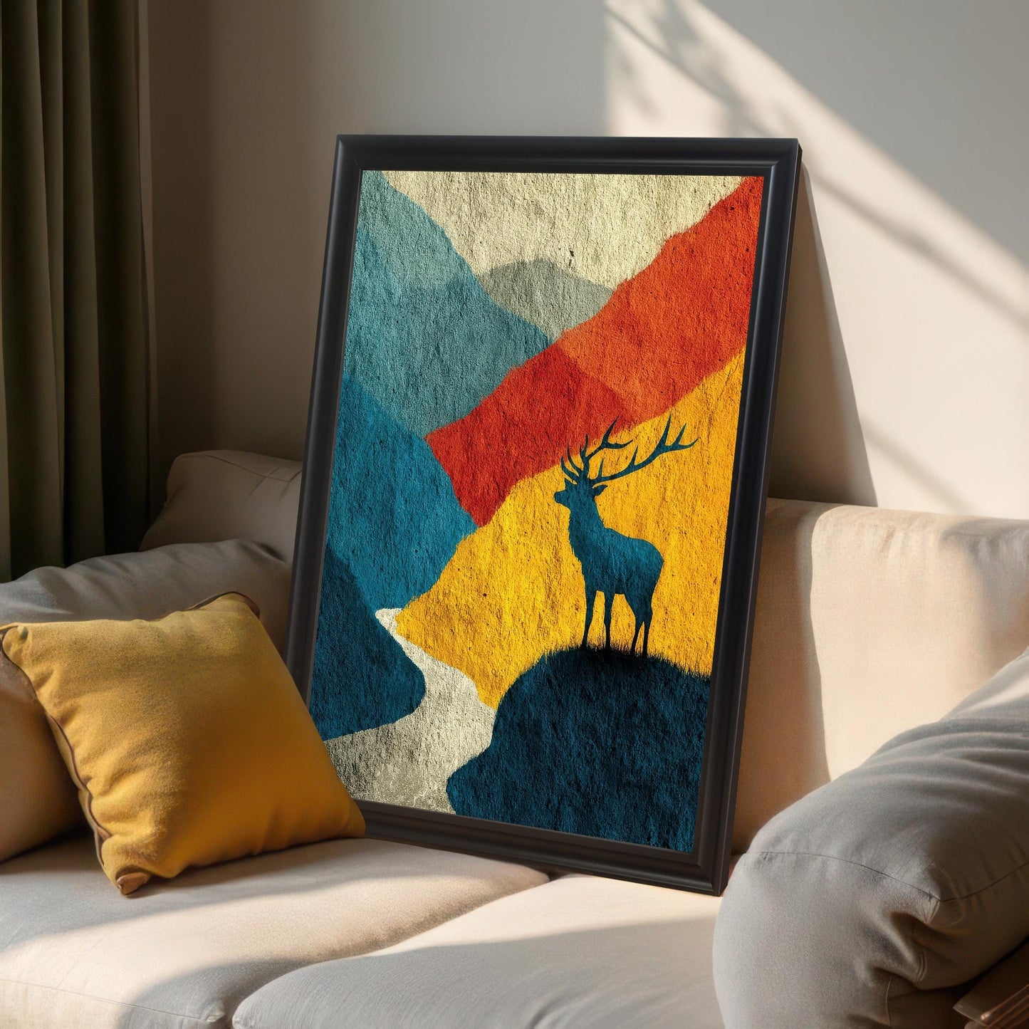 The artwork in a sleek "Black" wood frame without a mount, leaning against a neutral-toned sofa with a yellow pillow in a sunlit room.