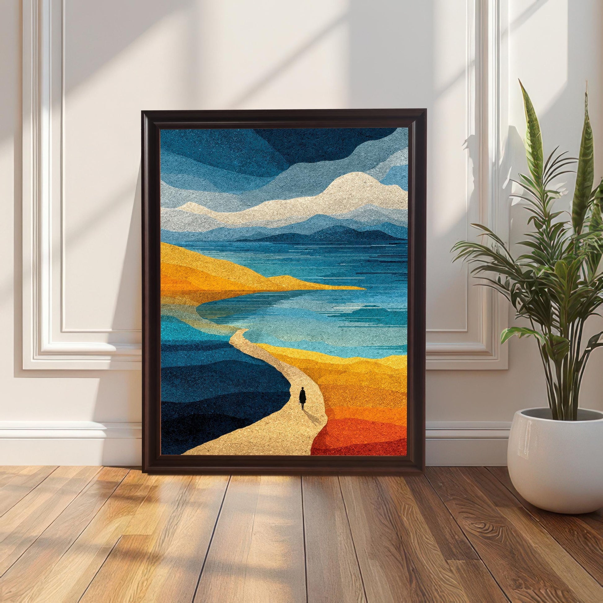 Dark coffee-colored wood framed abstract landscape print featuring a lonely figure on a path by the sea, leaning against a white wall in a modern living room setting with hardwood floors.