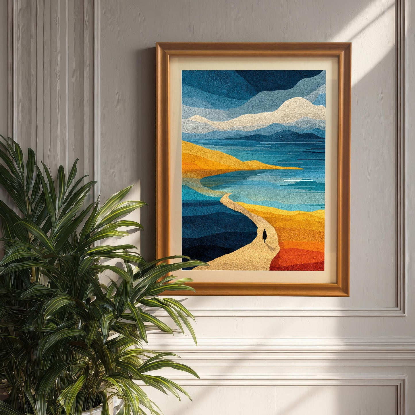 Orange wood framed abstract coastal landscape with a white mat, hanging on a classic white paneled wall next to a lush green indoor plant.