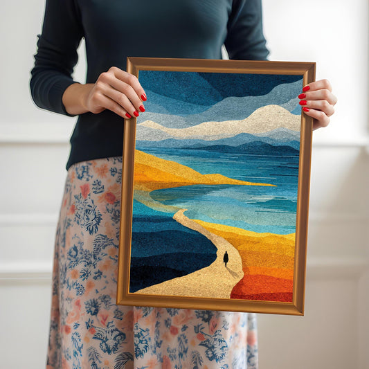A person holding a medium-sized orange wood framed abstract art print, showing the scale and vibrant blue and yellow colors of the landscape.
