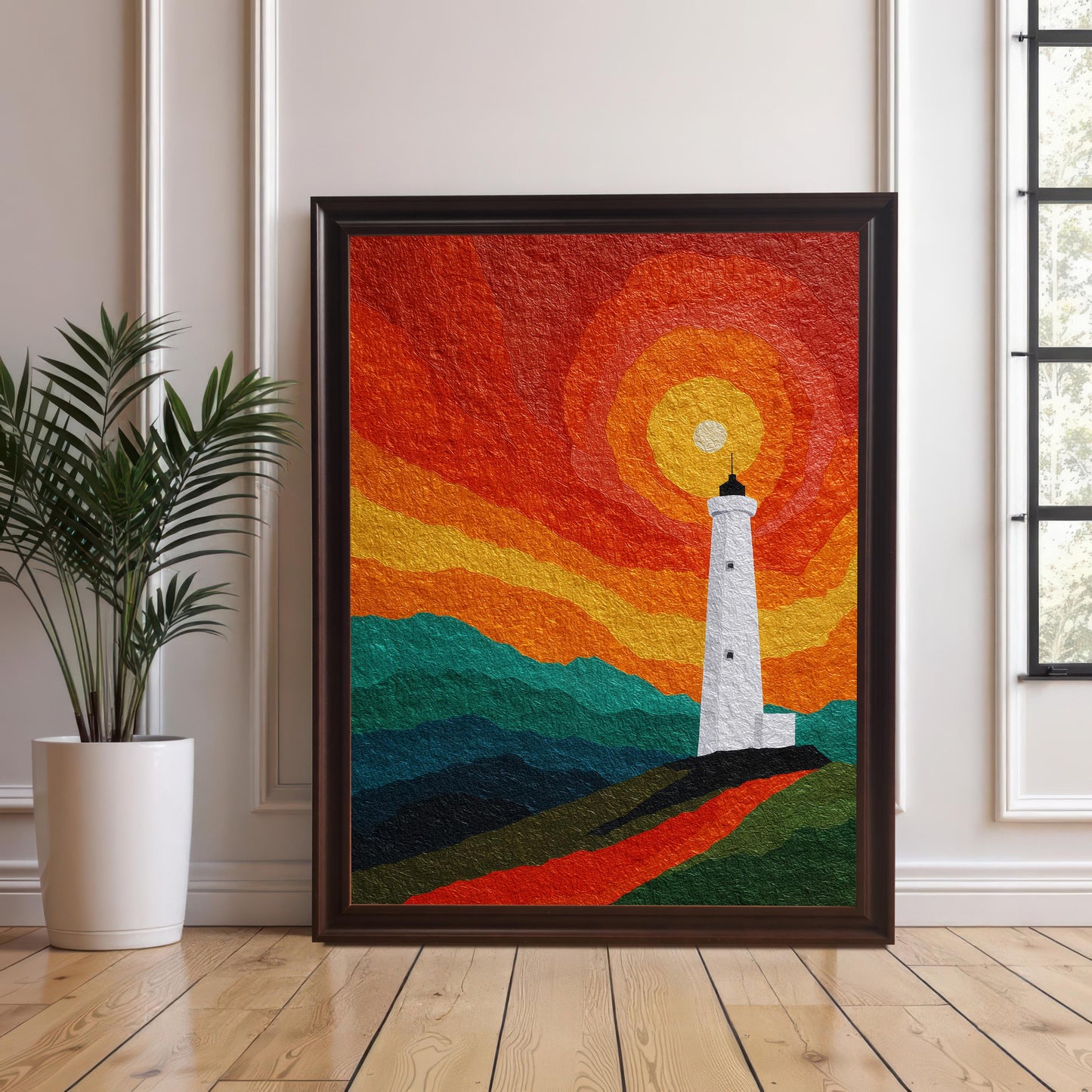 A large lighthouse art print in a dark coffee wood frame, leaning against a white wainscoted wall on a light oak wood floor next to a potted green plant.