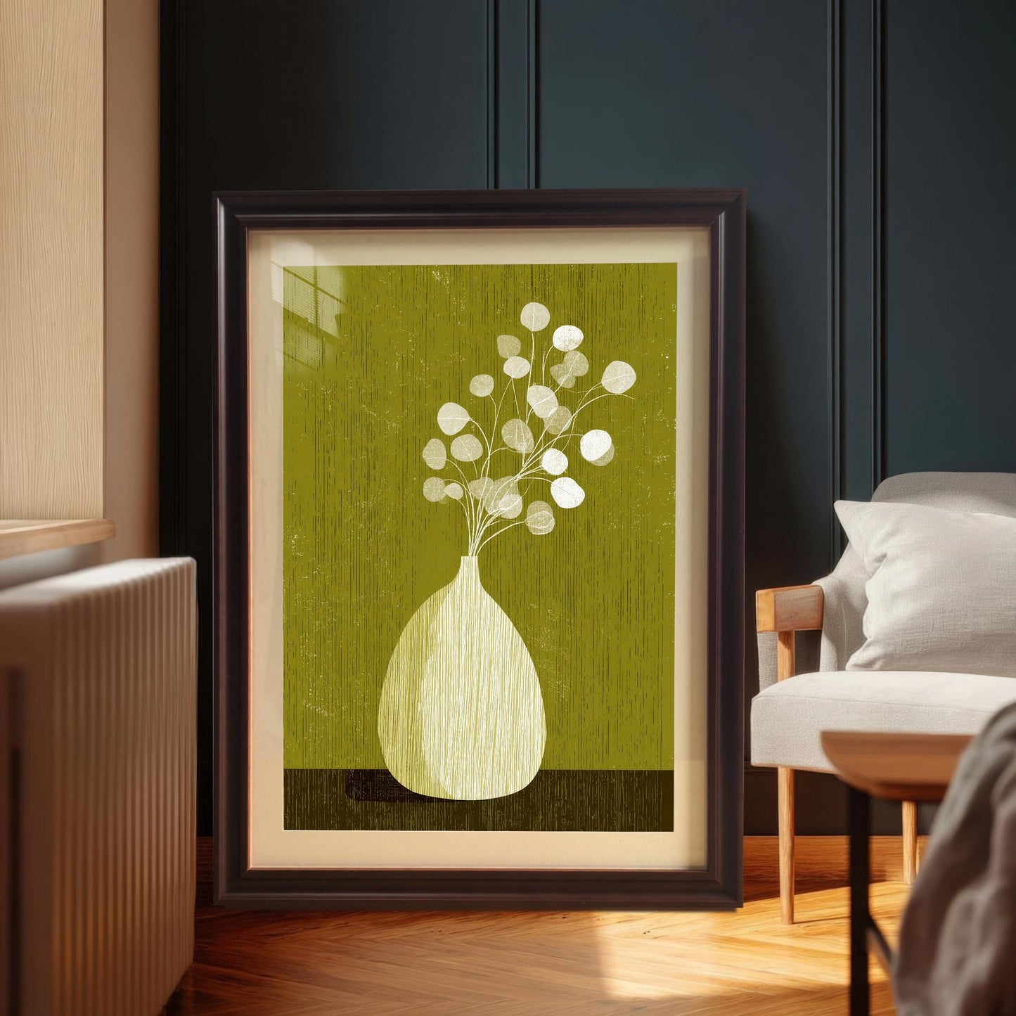 Large-scale botanical art print in a coffee-colored wood frame with a white mount, leaning on a hardwood floor in a modern interior setting.