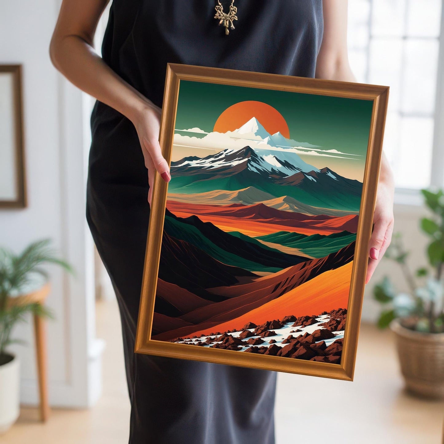A person in a black dress holding the orange-framed mountain art print to provide a real-world sense of scale and wood grain detail.