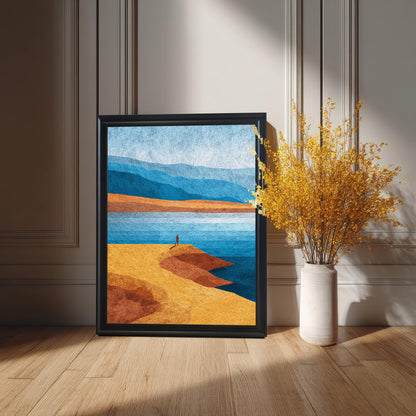 Large black framed minimalist landscape print leaning on a light oak floor against a cream wall, styled with a tall vase of vibrant yellow dried flowers in sunlight.