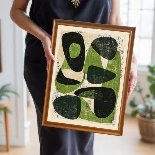A person holding the orange-framed abstract print, providing a real-life sense of scale and showing how the mid-century modern design looks in a lifestyle setting.