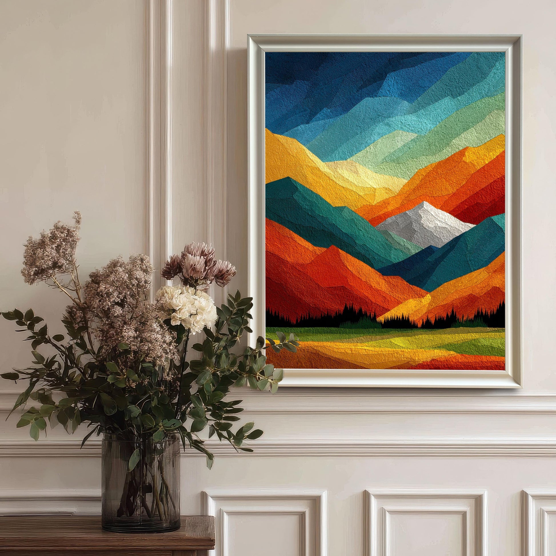 Bright, white wood-framed abstract landscape print hanging on a classic wainscoted wall next to a glass vase of dried flowers.