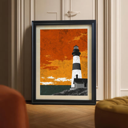 A large black wood-framed lighthouse art print with a white mount, leaning against a neutral wall on a herringbone wood floor in a modern room setting.