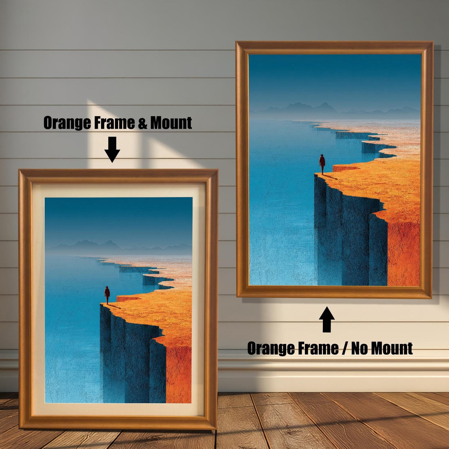 A comparison display showing two versions of an orange-wood framed landscape print on a white shiplap wall. The left version includes an off-white mount (mat), while the right version is a full-bleed print with no mount.