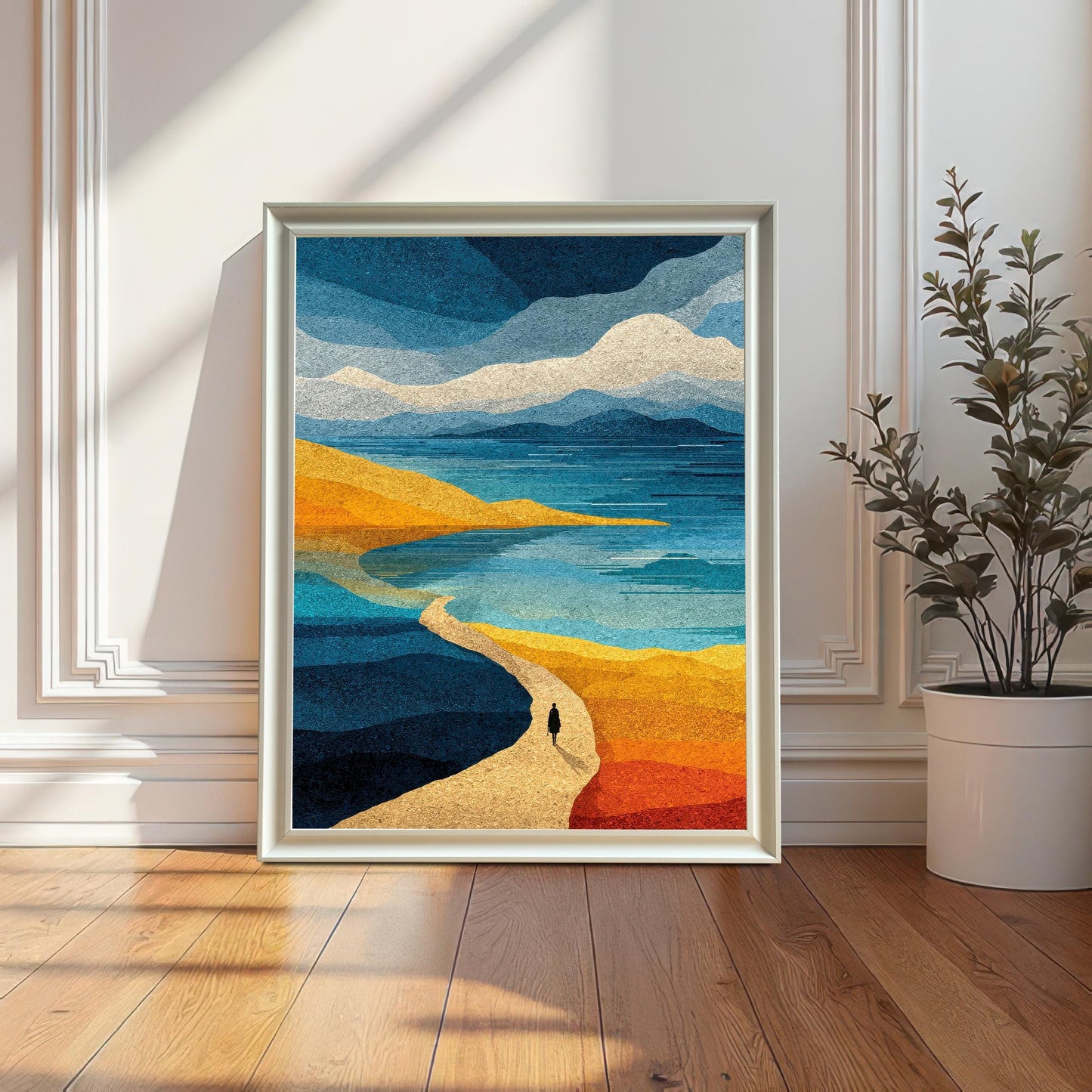 A white wood framed abstract seaside art print without a mount, displayed leaning against a bright white paneled wall on a polished hardwood floor next to a potted indoor plant.