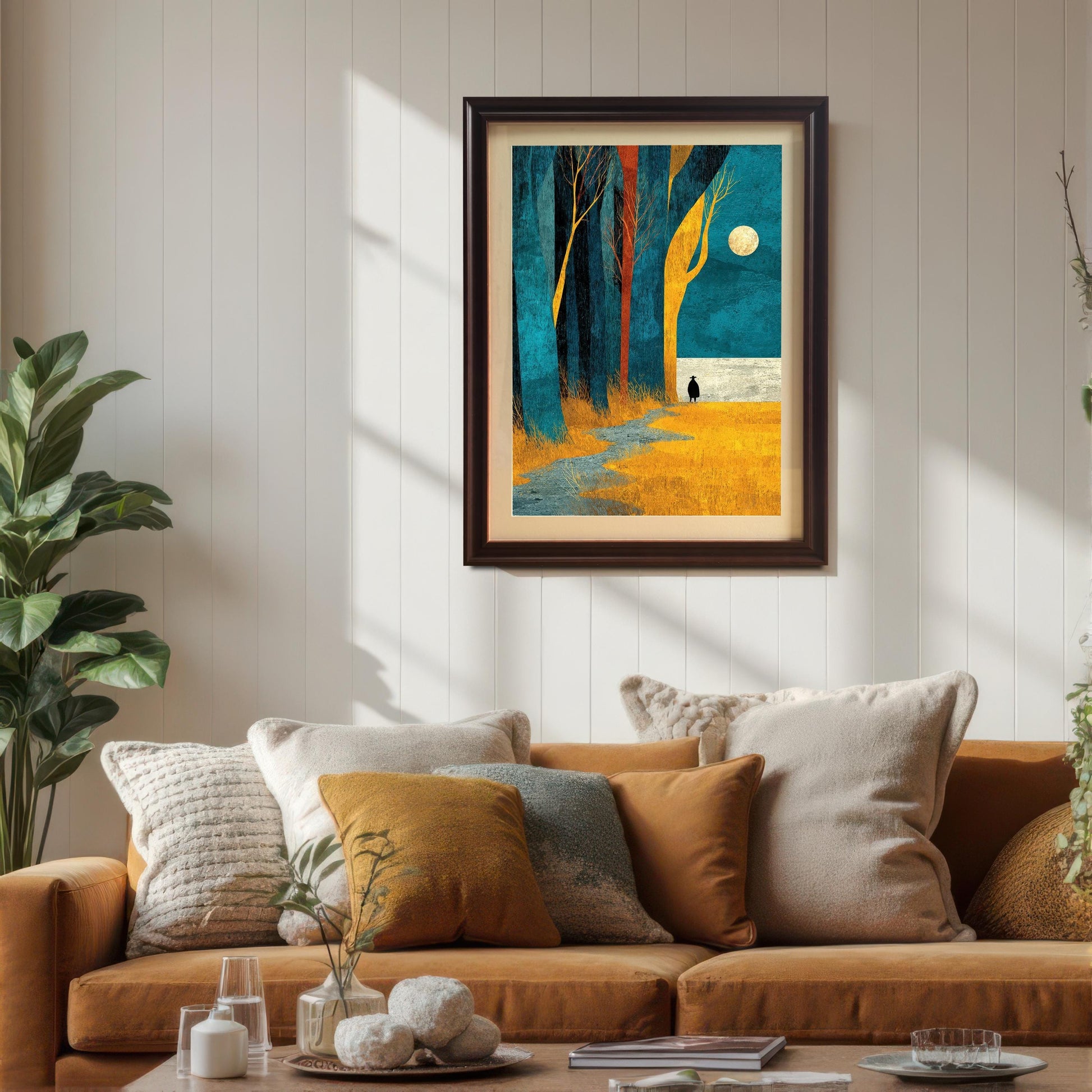 The framed forest art print with a cream mount board hanging above a warm, mustard-yellow sofa decorated with various textured throw pillows in a cozy living room.