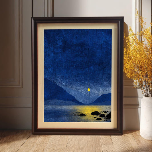 Coffee wood framed blue mountain art print leaning on a light oak floor against a cream wall, styled next to a tall white vase of yellow flowers.