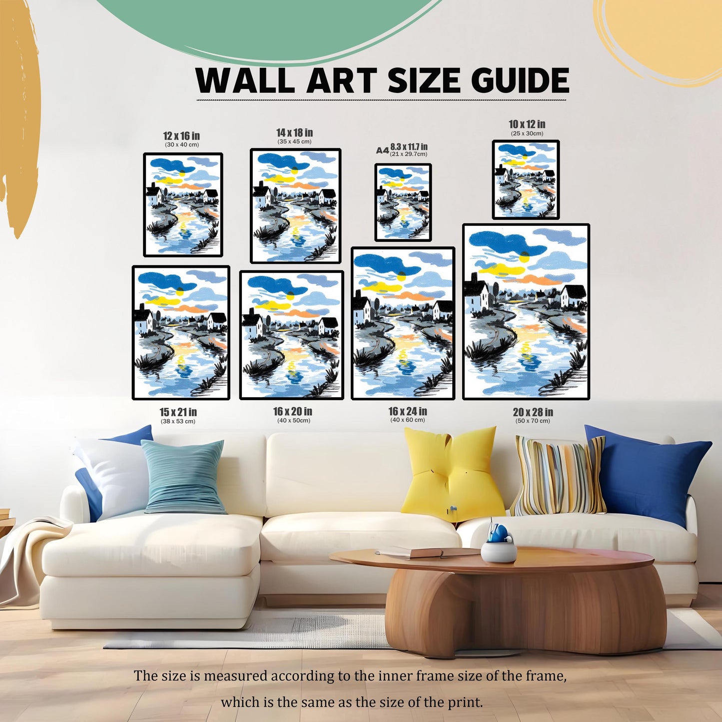 A ""WALL ART SIZE GUIDE"" image showing a framed sketch-style print of a river reflecting a colorful sunset/sunrise sky, with white houses on its banks. The art is displayed in eight different size options (12x16, 14x18, A4, 10x12, 15x21, 16x20, 16x24, 20x28 inches) above a white sectional sofa