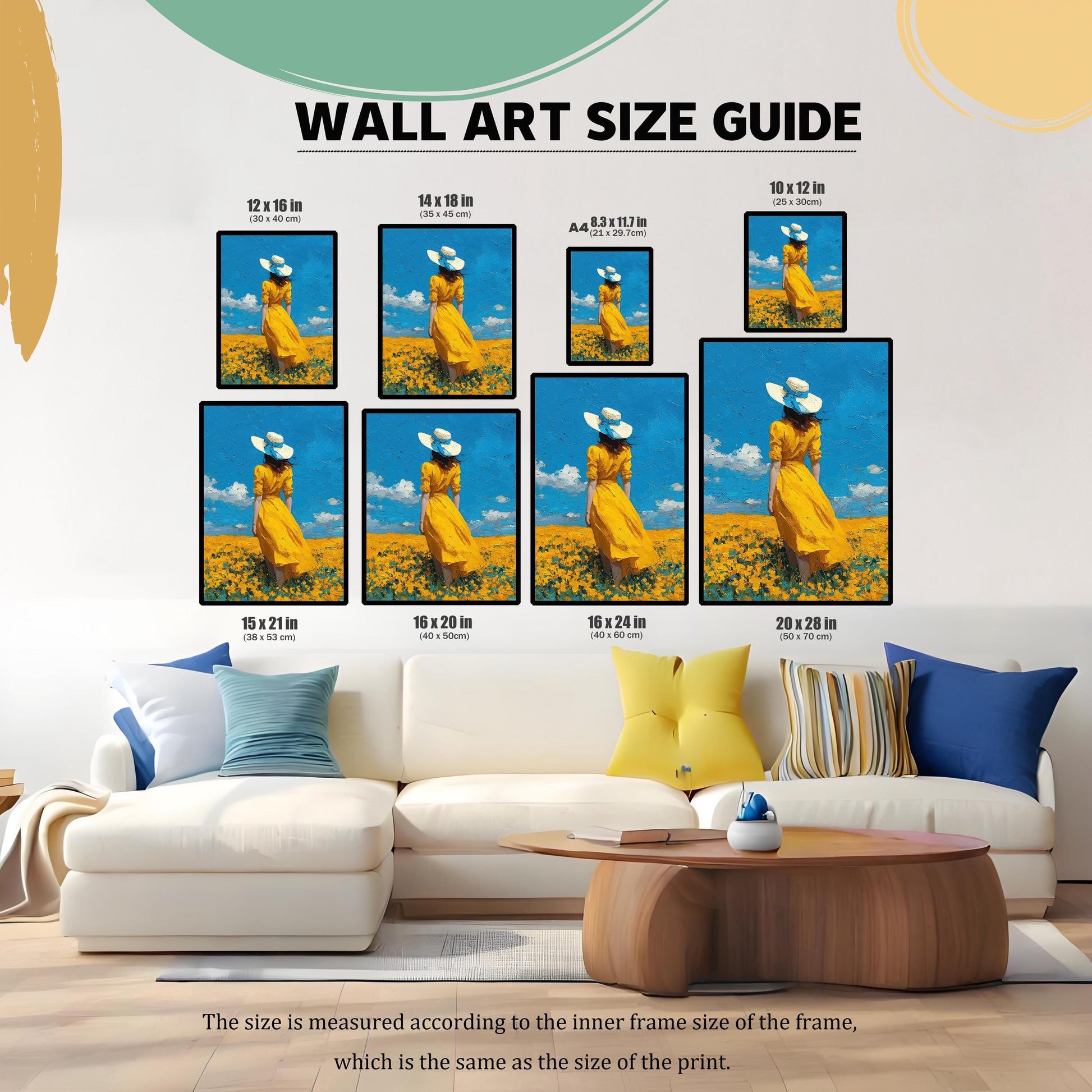 A wall art size guide showing the same art print in various dimensions, displayed on a wall above a white couch with different colored pillows.