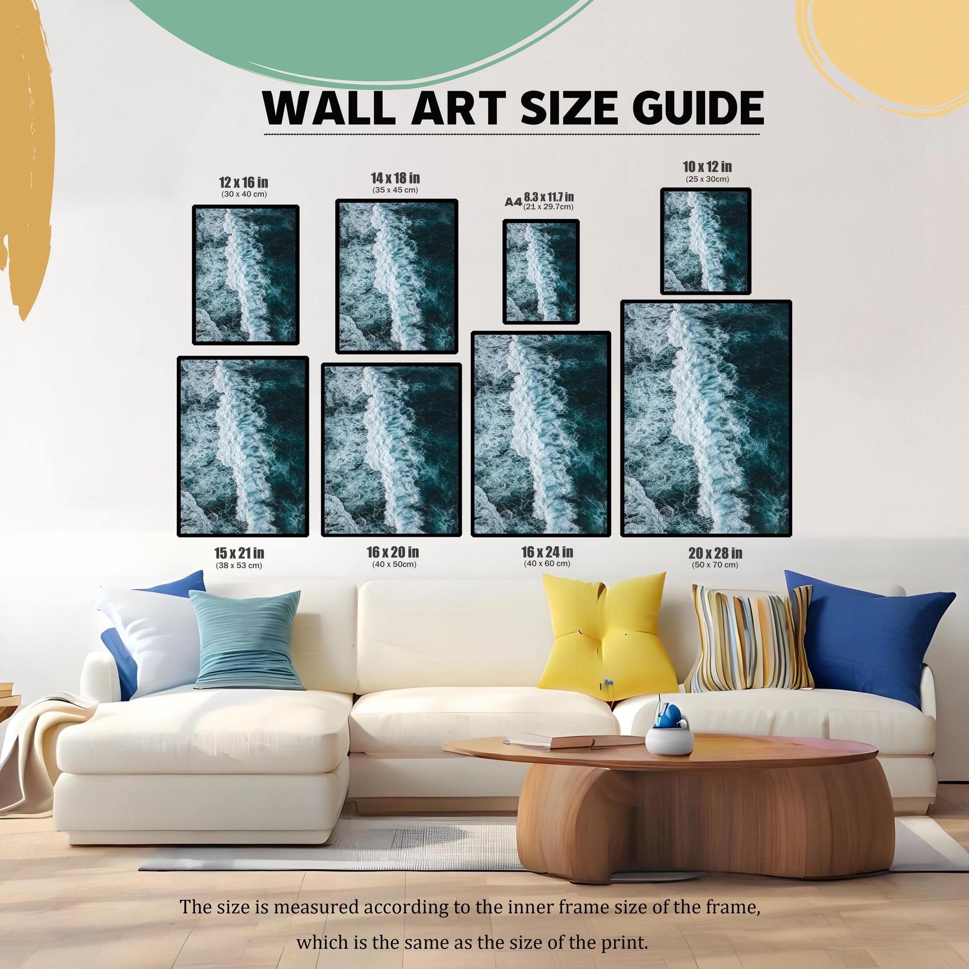 Wall art size guide showing different framed print sizes (e.g., 12×16 in, 16×24 in, 20×28 in) displayed above a white sectional sofa, helping customers visualize the scale of the dark blue ocean wave print in a living room setting.