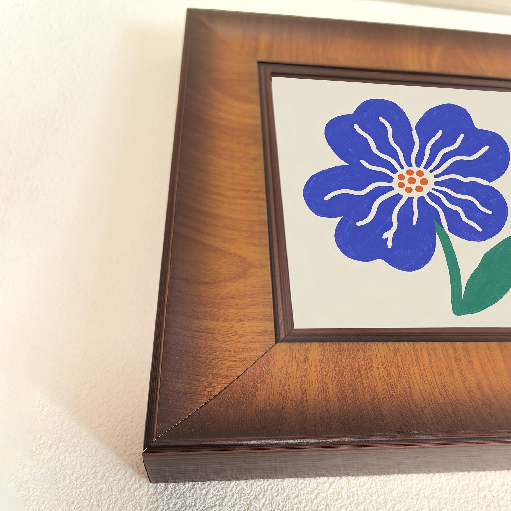 Close-up shot of a thick, dark walnut-finished wooden frame showcasing the wood grain texture and the vibrant blue floral print.