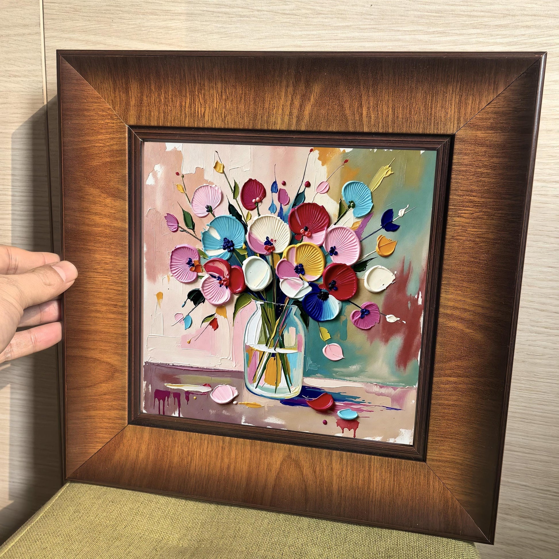 Close-up of a square wood-framed wall art featuring a 3D impasto oil painting of colorful flowers in a glass vase with thick, textured brushstrokes.