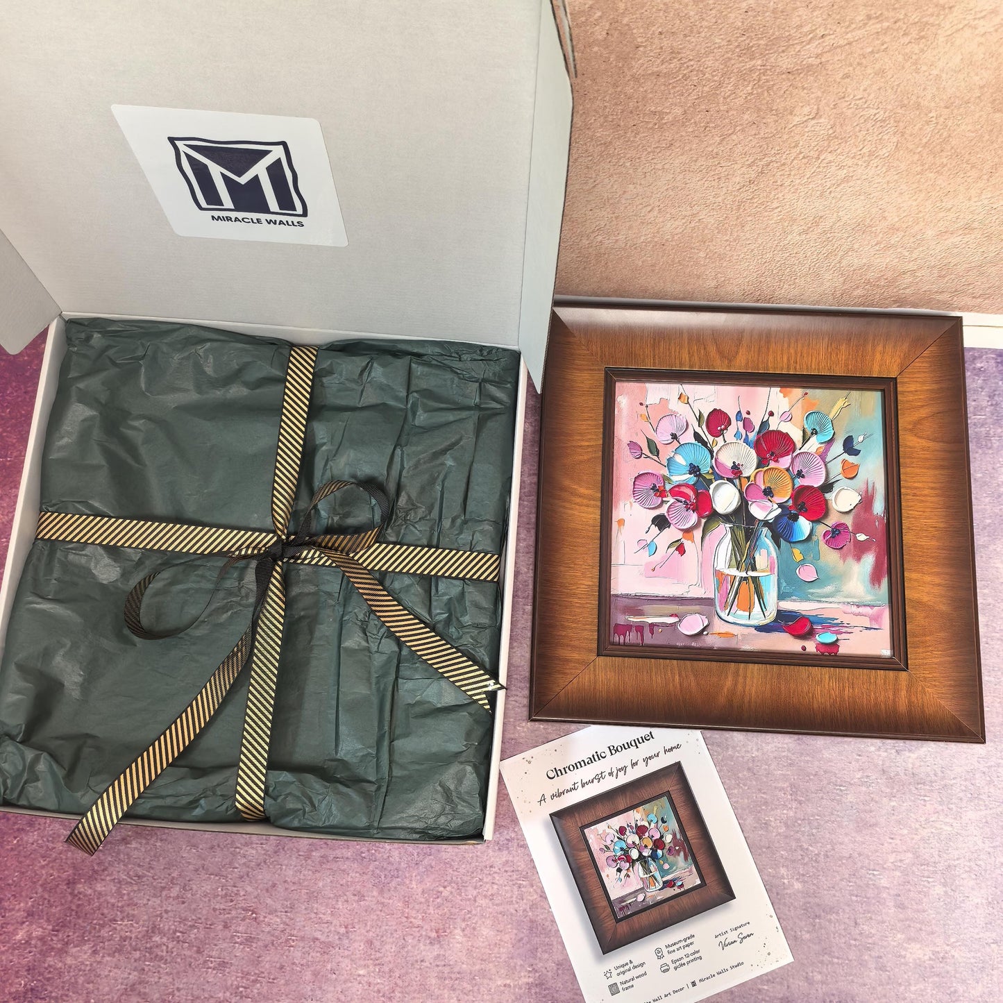 A "Chromatic Bouquet" wood-framed art print featuring vibrant, 3D-style colorful flowers in a glass vase. The print is displayed next to its premium gift packaging—a white Miracle Walls box with green tissue paper and a gold-striped ribbon—and a product certificate of authenticity.