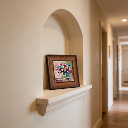 Decorative wood-framed painting of colorful 3D flowers displayed inside a wall niche in a bright, minimalist hallway.