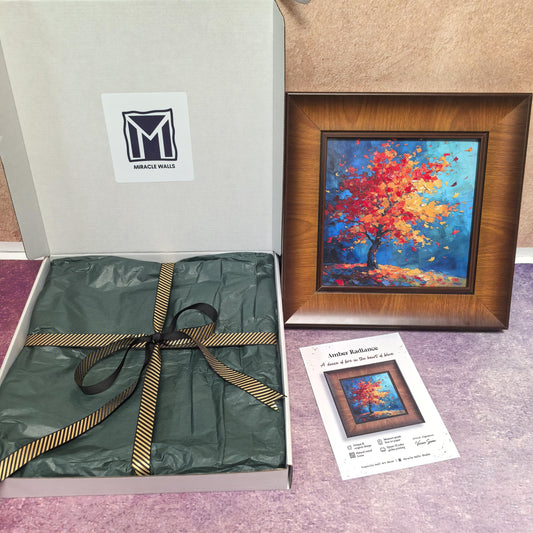 An unboxing display featuring a square, dark wood-framed art print titled "Amber Radiance" next to its white branded packaging. The box includes a "Miracle Walls" logo, green tissue paper, and a gold-striped black ribbon.