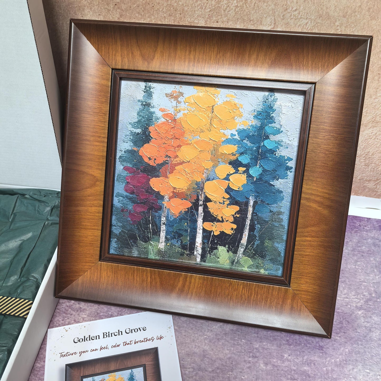 A direct view of the "Golden Birch Grove" framed art, highlighting the thick, impasto texture of the yellow, orange, and teal birch trees. The artwork is encased in a wide, elegant wood frame with a warm brown finish.