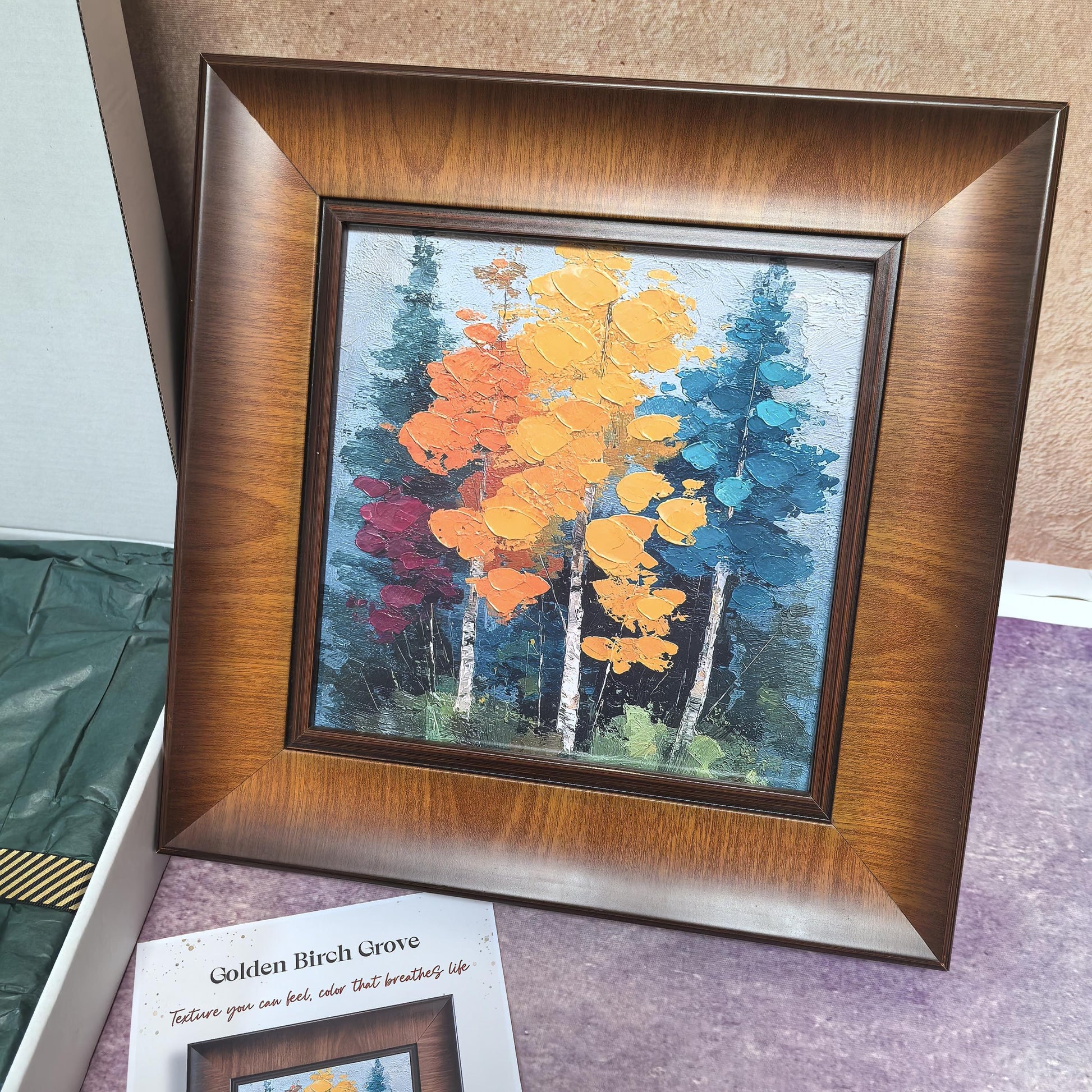 A direct view of the "Golden Birch Grove" framed art, highlighting the thick, impasto texture of the yellow, orange, and teal birch trees. The artwork is encased in a wide, elegant wood frame with a warm brown finish.