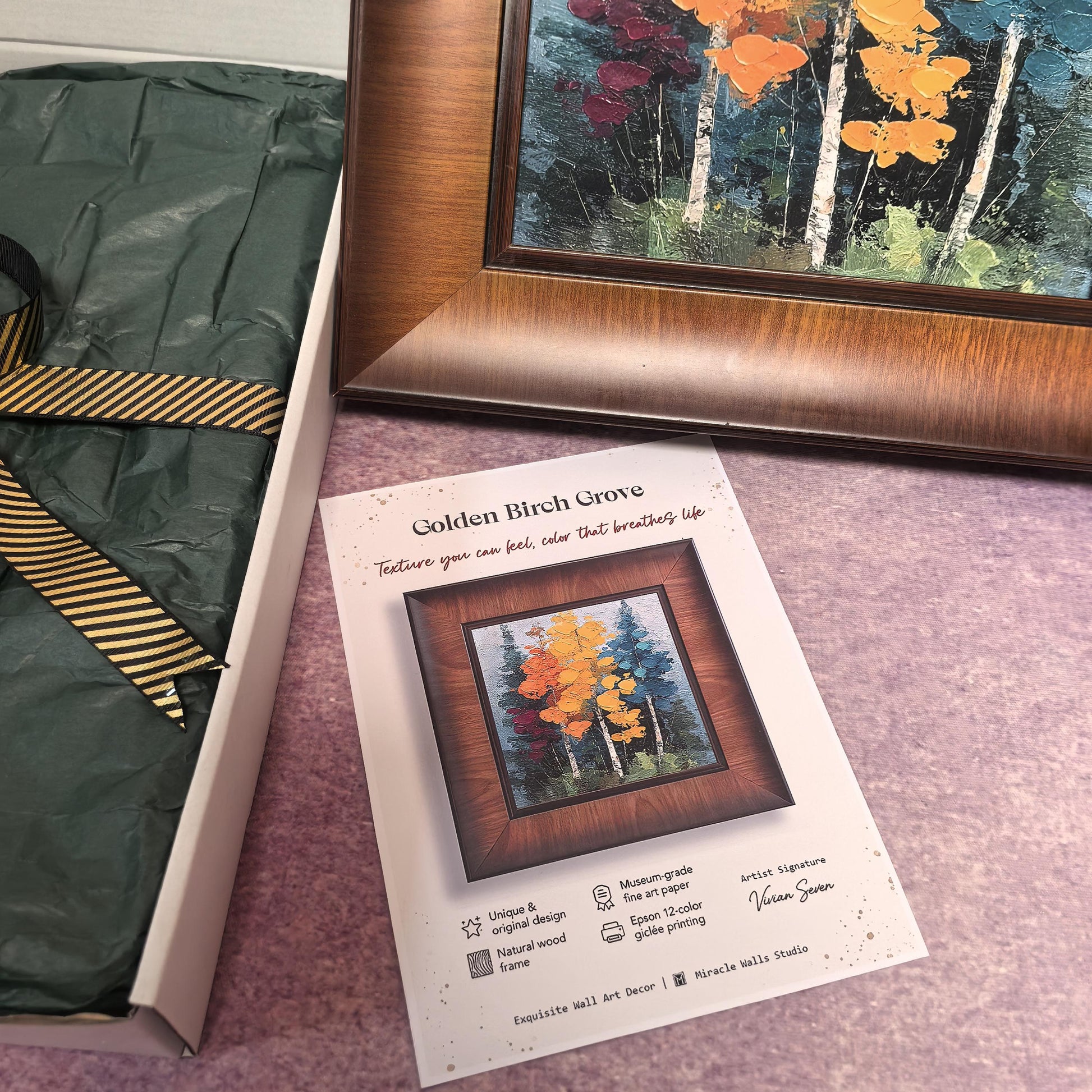 A close-up focus on the "Golden Birch Grove" information card, which details the museum-grade fine art paper and 12-color giclée printing process. A corner of the textured frame and the gift-wrapped box are visible in the background.