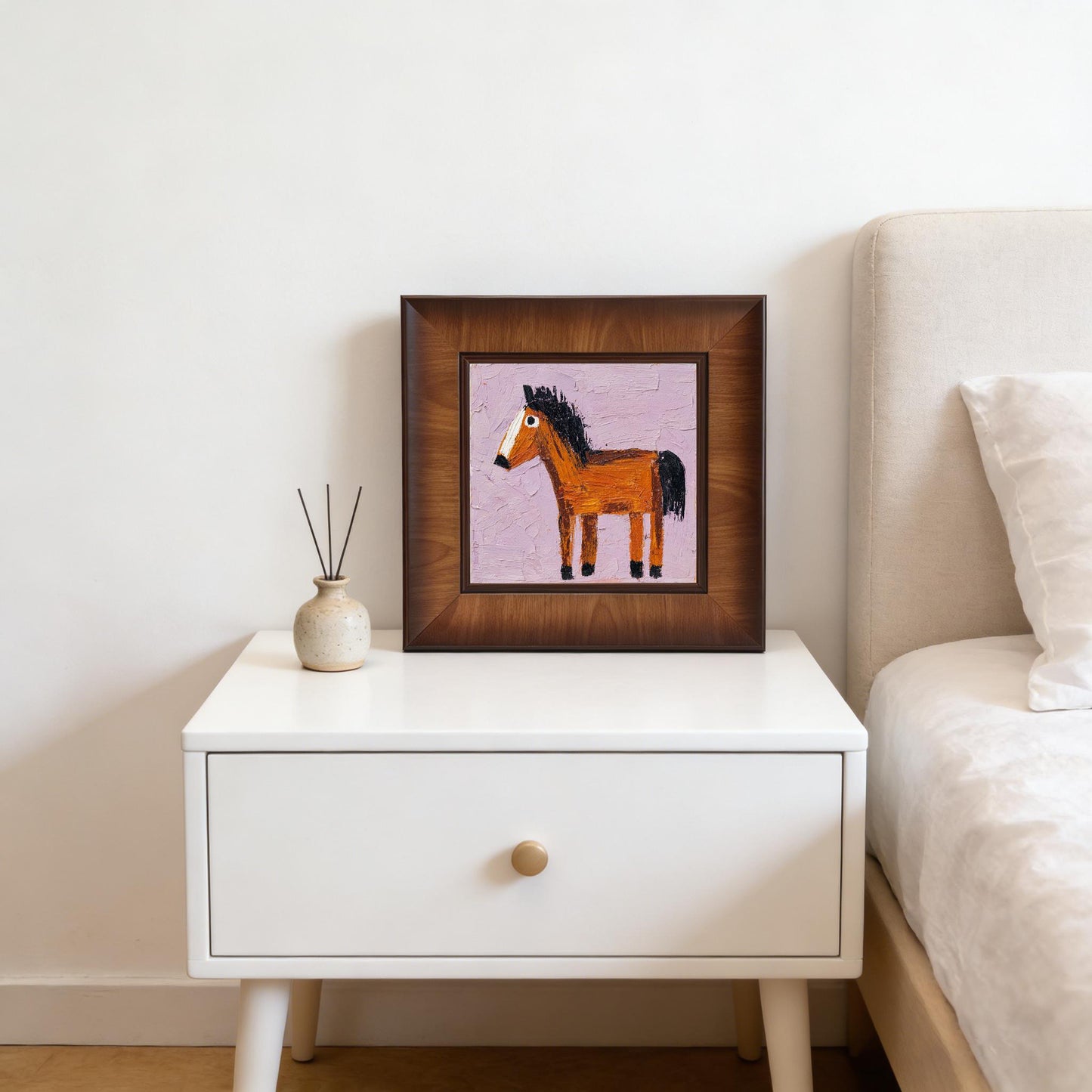 Minimalist decor featuring the wood-framed horse print sitting on a white mid-century modern nightstand next to a bed.