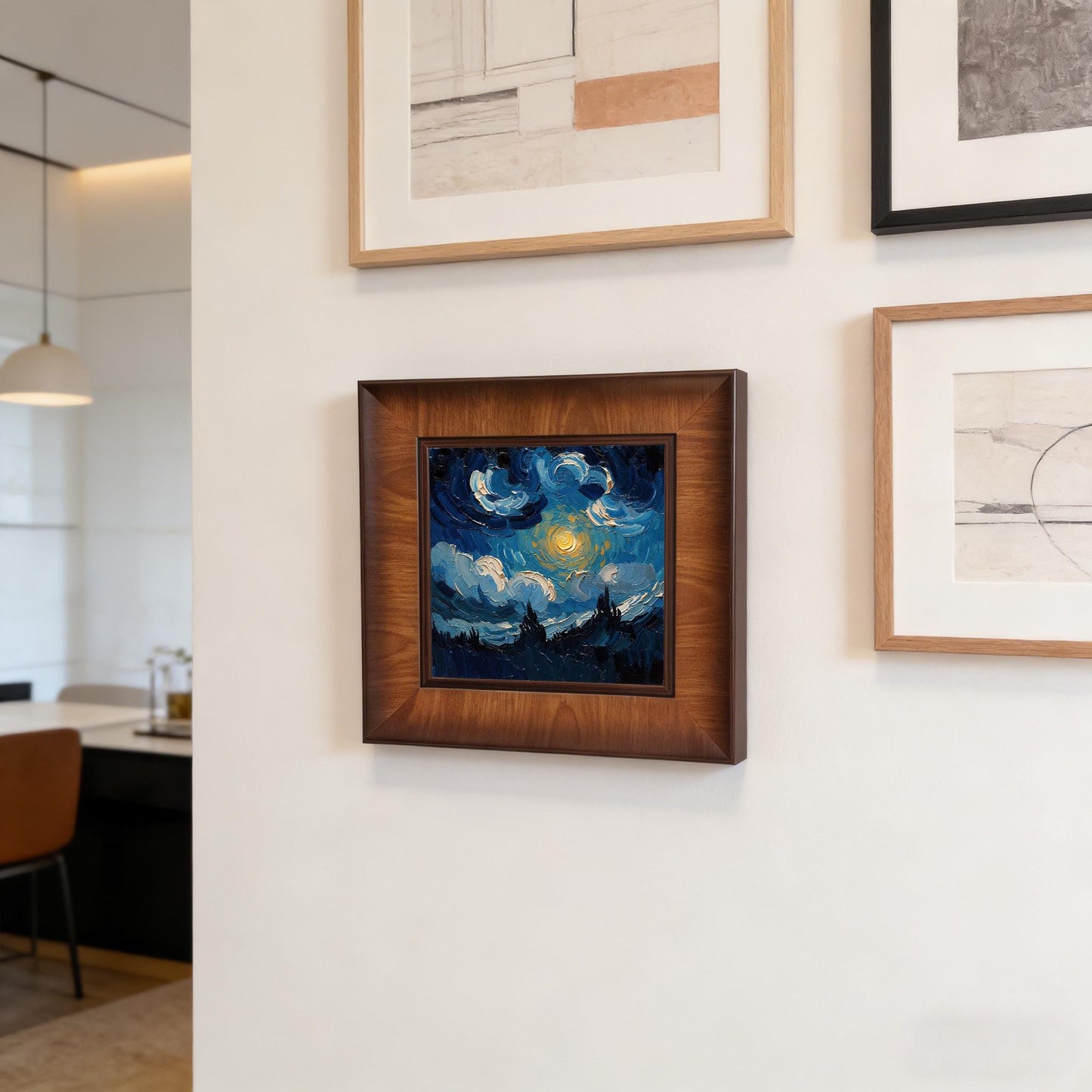 Close-up of a square wooden framed wall art piece hanging as part of a gallery wall set in a modern, bright dining area with minimalist furniture.