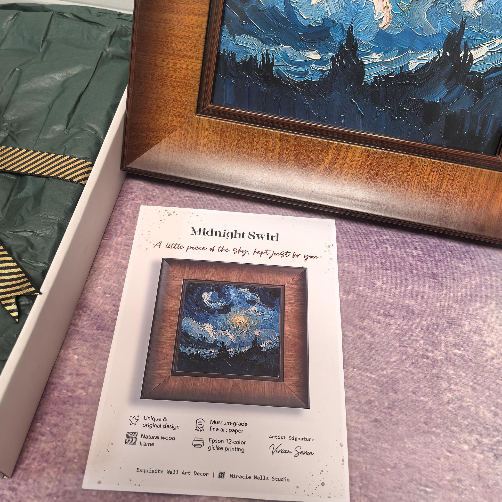 An unboxing scene featuring the "Midnight Swirl" print. The framed artwork is shown next to its open "Miracle Walls" gift box, which is filled with dark green tissue paper and tied with a gold-and-black striped ribbon.
