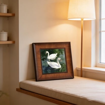 Square swan watercolor print in a thick wooden frame, leaning against a wall on a cozy cream window seat next to a warm floor lamp.